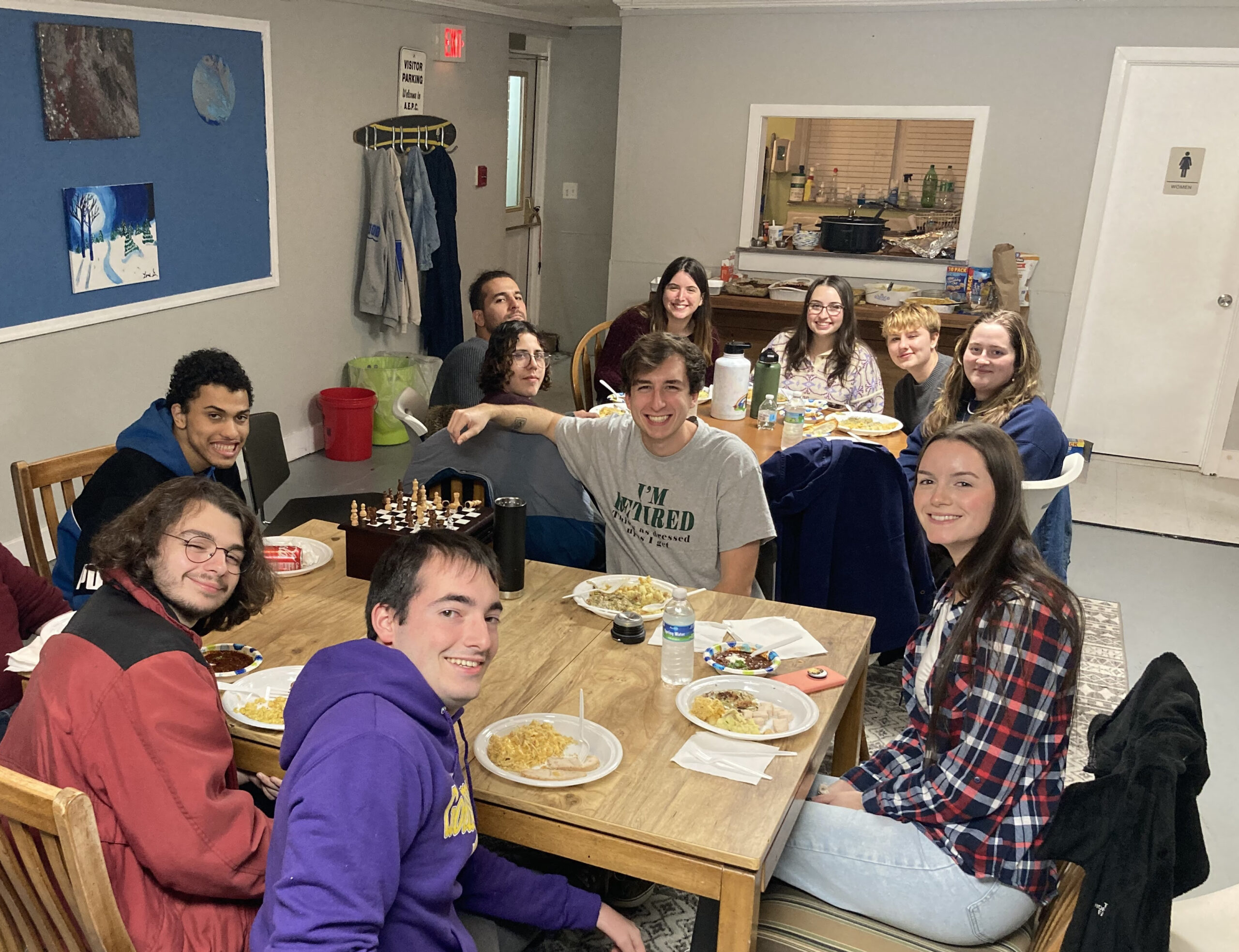 A young adult small group meets together for dinner.